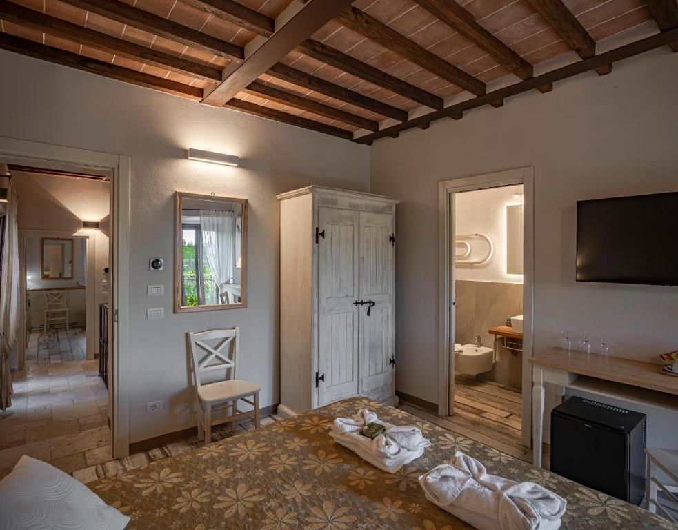 Pokój z łóżkiem, telewizorem i kominkiem w obiekcie Il Casale Del Cotone w mieście San Gimignano