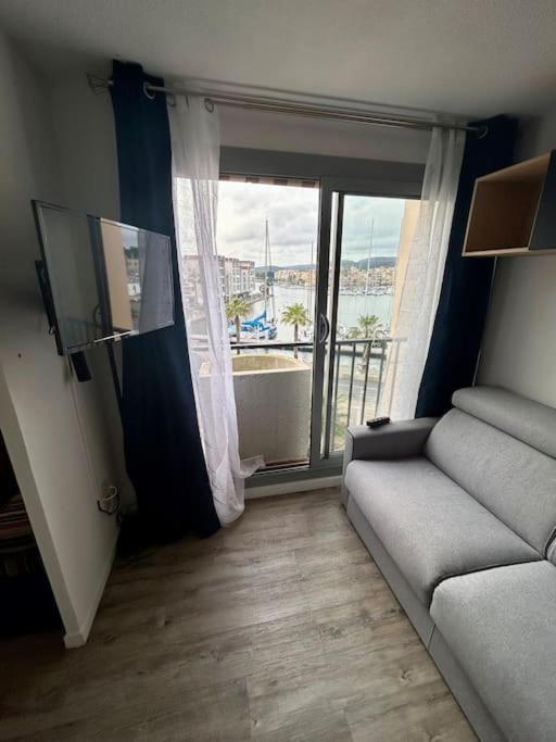un salon avec un canapé et une grande fenêtre dans l'établissement Studio avec vue sur le port, à Gruissan