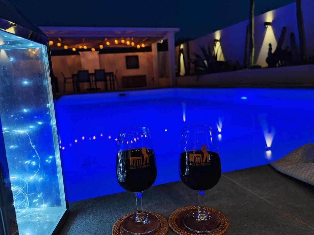- deux verres de vin assis à côté de la piscine dans l'établissement Villa de la Raho, à Villeneuve-de-la-Raho