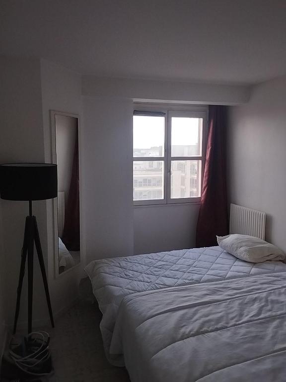 une chambre avec un grand lit et deux fenêtres dans l'établissement Chambre à louer Lit double, à Noisy-le-Grand