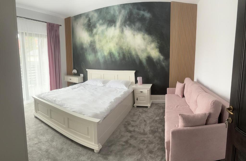a bedroom with a white bed and a couch at Dorna Retreat in Vatra Dornei