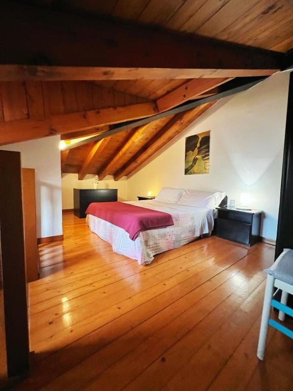 a bedroom with a large bed in a room with wooden floors at Holiday Treviso Suite Venezia in Treviso