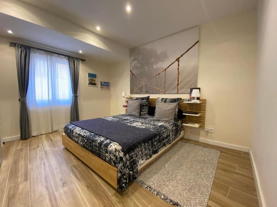 une chambre avec un lit et une grande fenêtre dans l'établissement 2 pièces Vieux Nice - Deux pas de la mer, à Nice