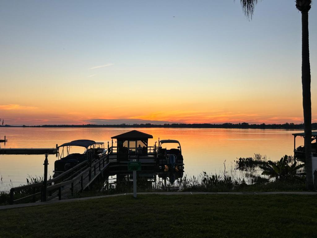 a playground on the water with the sunset in the background at Lakefront Duplex With Pontoon Boat Downtown in Mount Dora