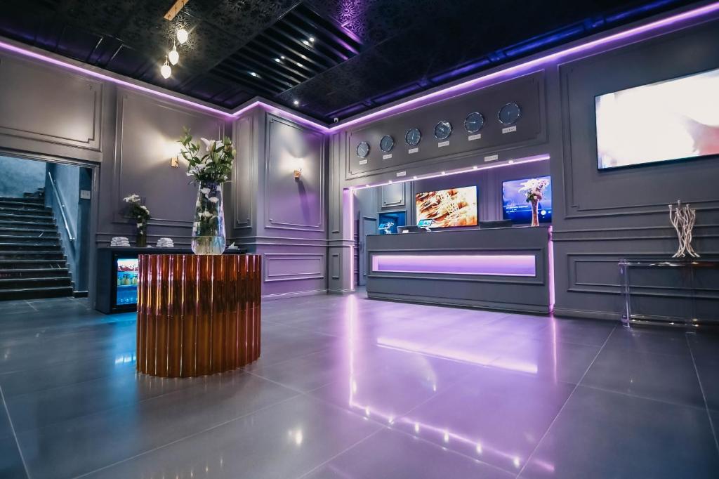 a room with a stage with purple lighting and a table at 555 Hotel Clubbing Adults Only in Marrakesh