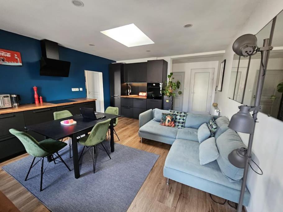 un salon avec un canapé bleu et une table dans l'établissement Le Roble - 5 min du centre de Strasbourg, à Strasbourg