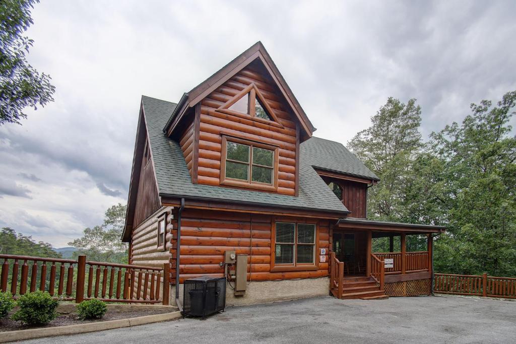 a wooden cabin with a gambrel roof and a porch at Belvedere by Eden Crest in Sevierville