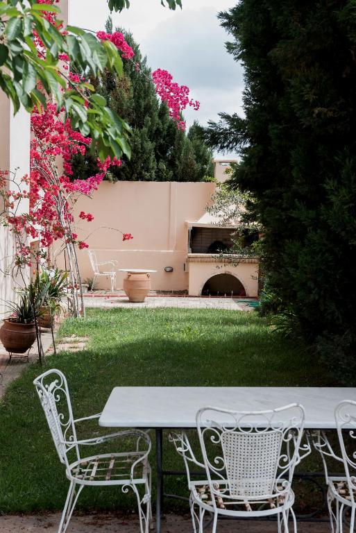a table and chairs in a yard with flowers at Villa Discover Evia - With Private Jacuzzi in Aliveri