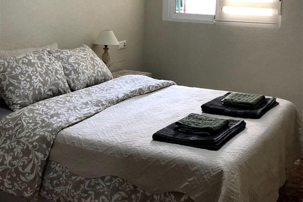 Una cama con dos bandejas sentadas encima. en Manda Pola, en Santa Pola