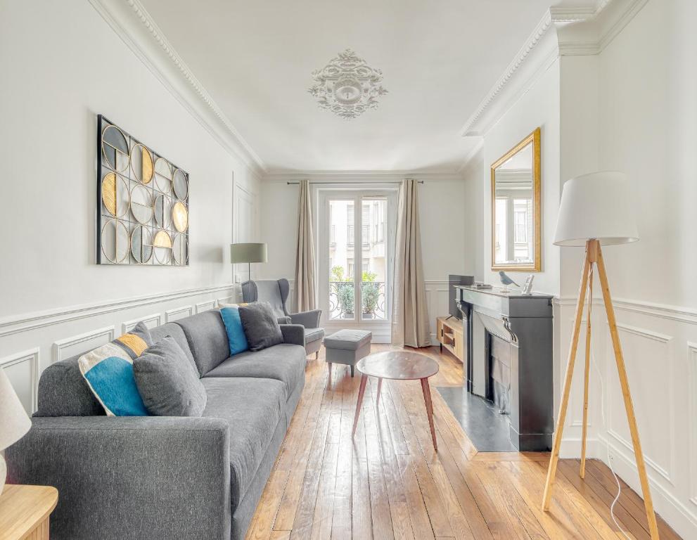 - un salon avec un canapé gris et une cheminée dans l'établissement Eiffel tower 10 minutes 1BR Renovated, à Paris