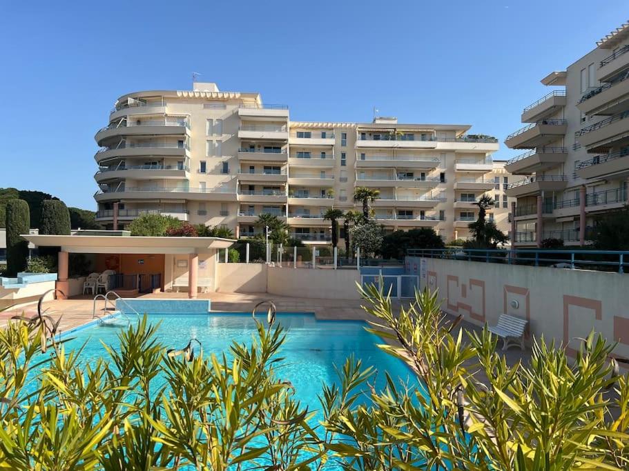 Appartement cosy piscine plage 2 pièces في فريجوس: حمام سباحة أمام مبنى كبير