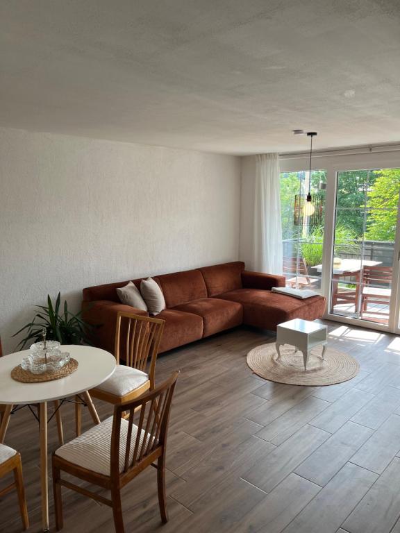 a living room with a couch and a table and chairs at Apartment Kastanienblick in Tettnang