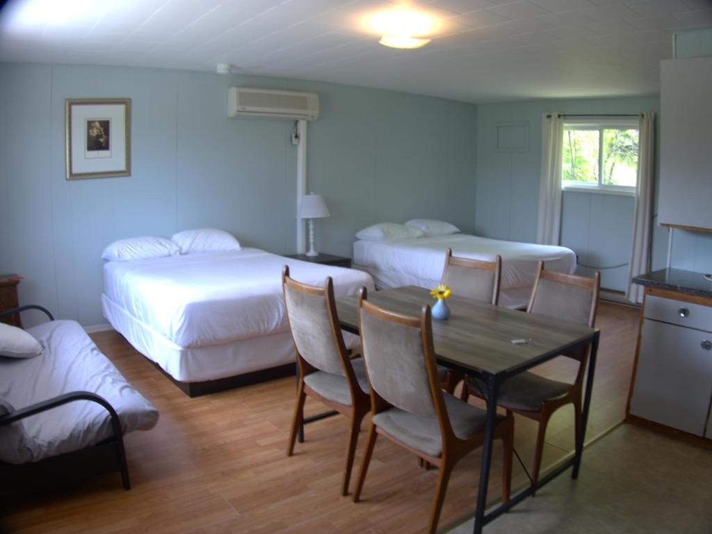a bedroom with a bed and a table and chairs at Port loring Northland Motel in Port Loring