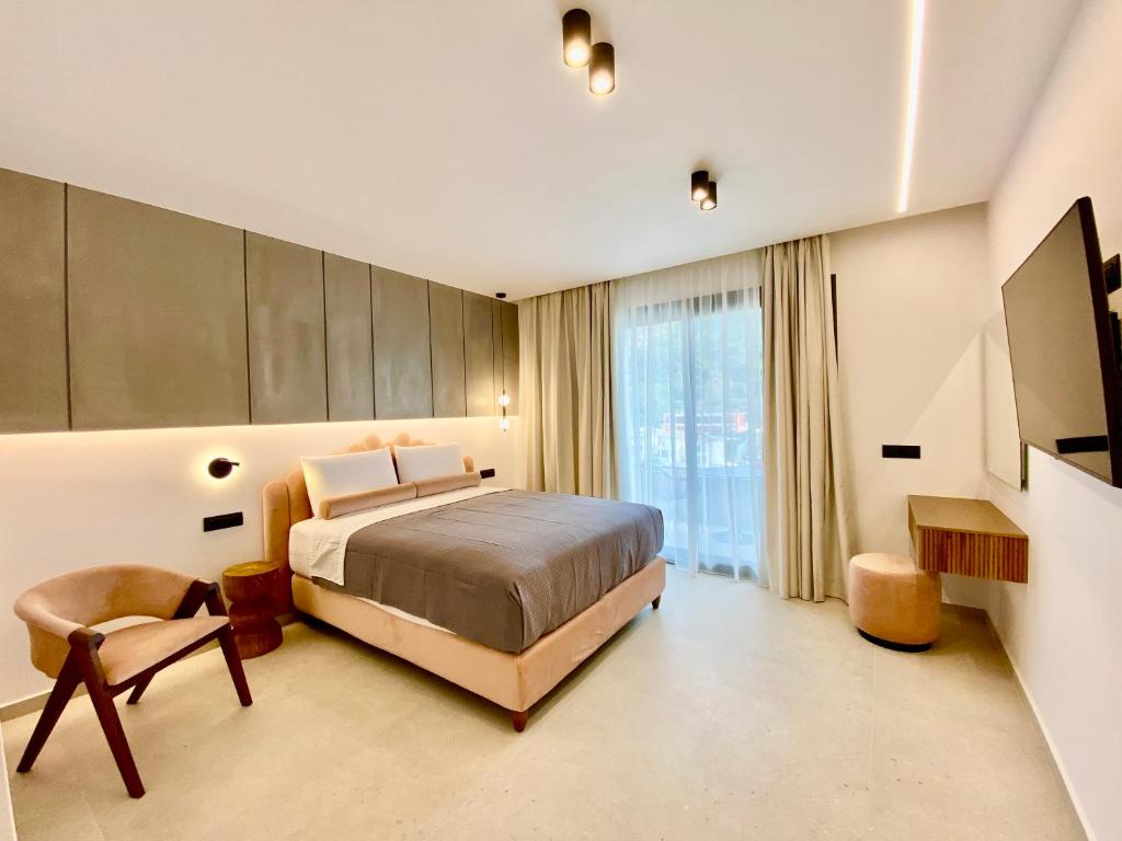 a bedroom with a bed and a large window at Tramonto Maisonettes & Suites in Parga