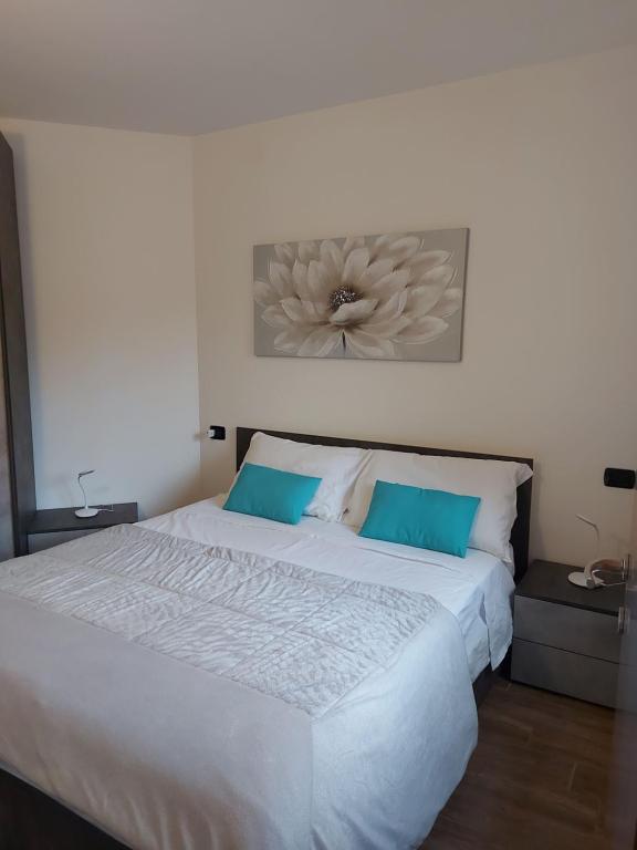 キエーザ・イン・ヴァルマレンコにあるLa Terrazza Apartmentの大きな白いベッドと青い枕のある寝室