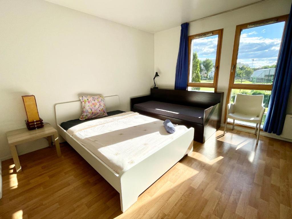 een slaapkamer met een bed, een bureau en een stoel bij Studio lumineux 10 min à La Défense 2 in Rueil-Malmaison