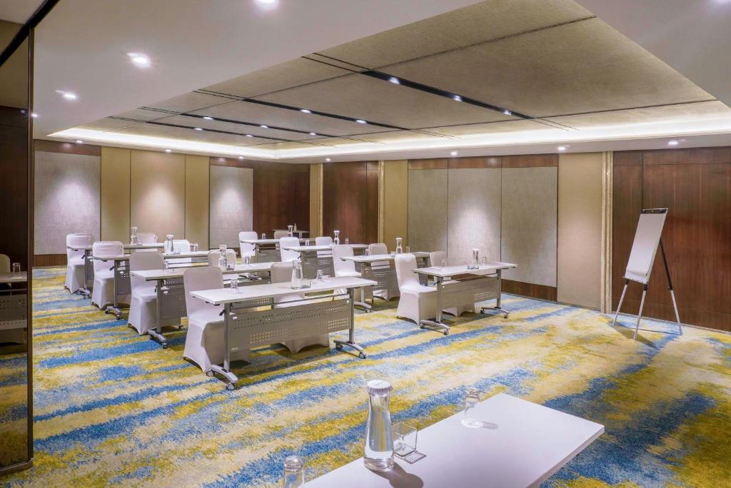 a conference room with tables and chairs and a podium at Radisson Lampung Kedaton in Bandar Lampung