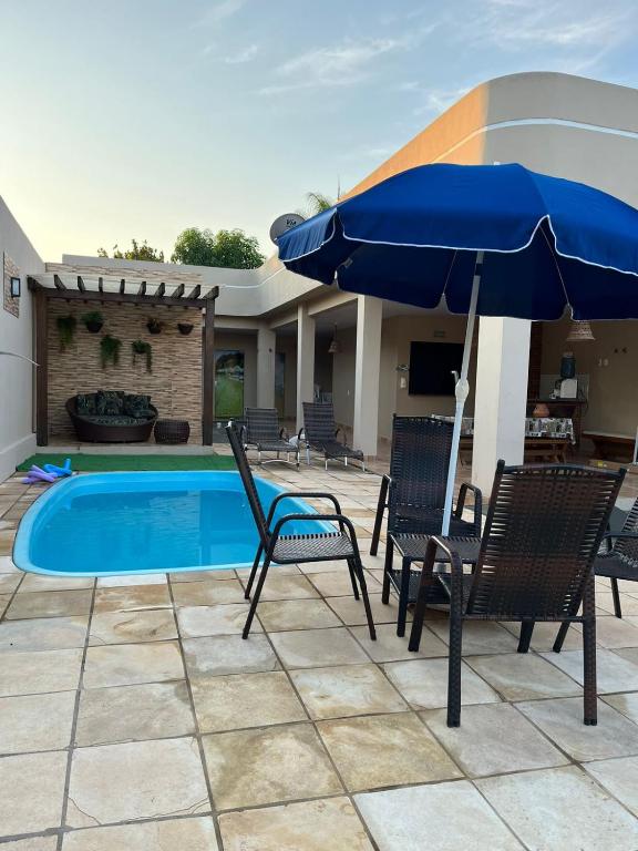 a patio with chairs and an umbrella next to a pool at Casa Ondas de Alter in Alter do Chao