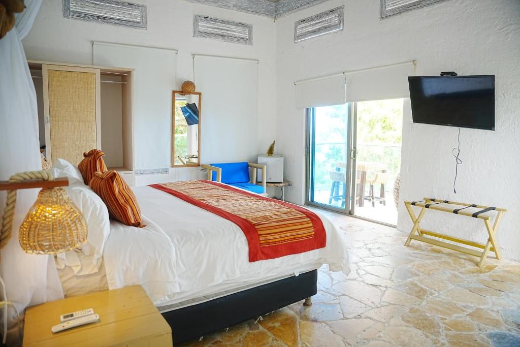 a bedroom with a large bed and a television at Hotel Isla Real in Tierra Bomba