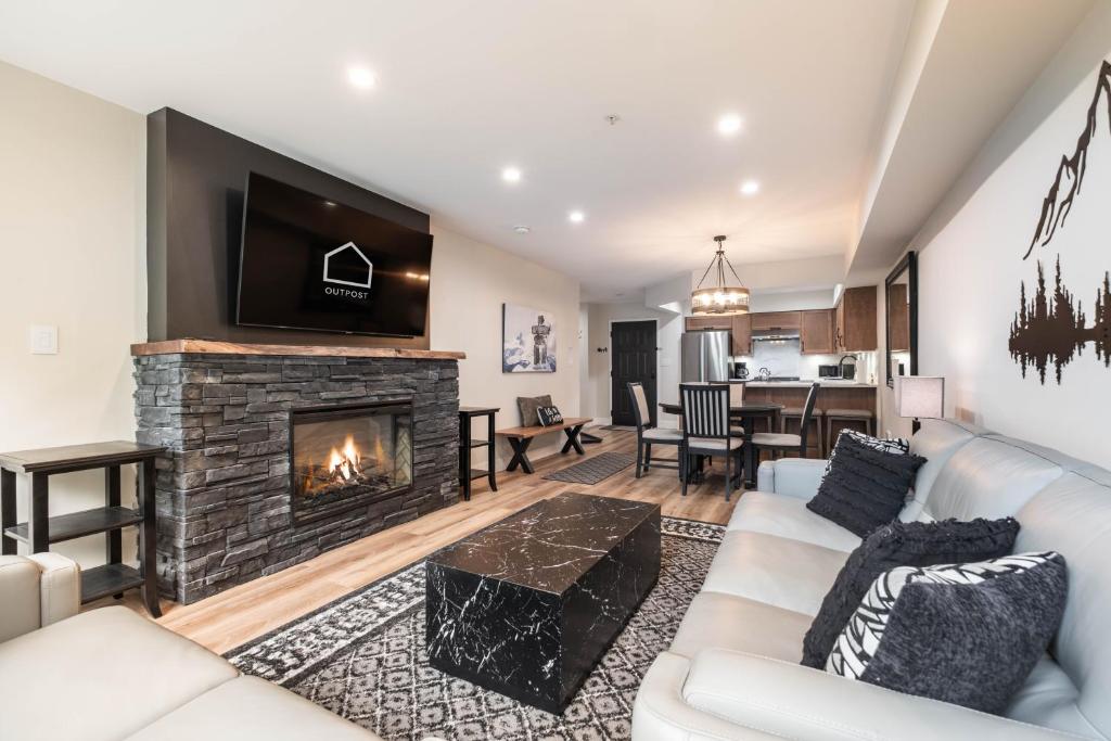 a living room with a couch and a fireplace at Powderhorn 205 by Outpost Whistler in Whistler