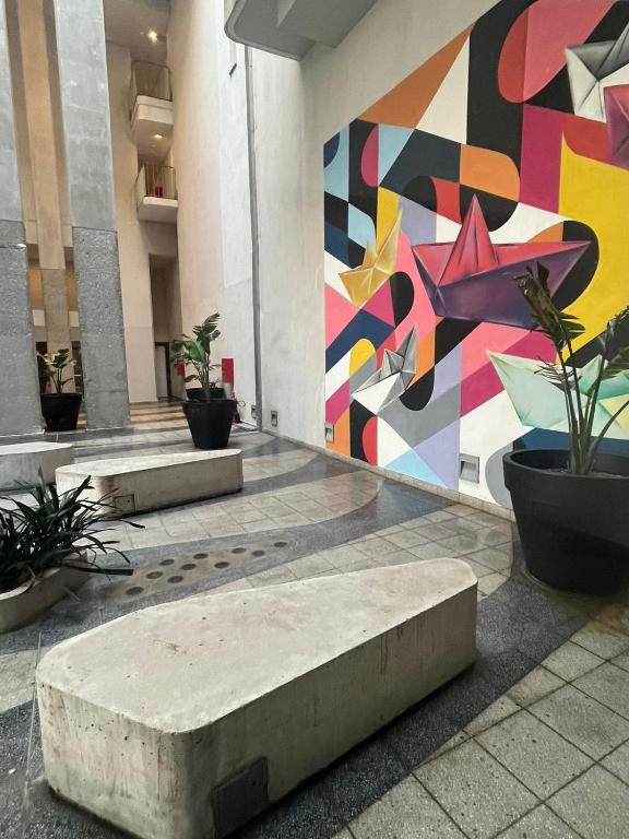 a mural on the side of a building with plants at Alojate en METRA Puerto Norte, luminoso estudio con pileta, gym y balcon in Rosario