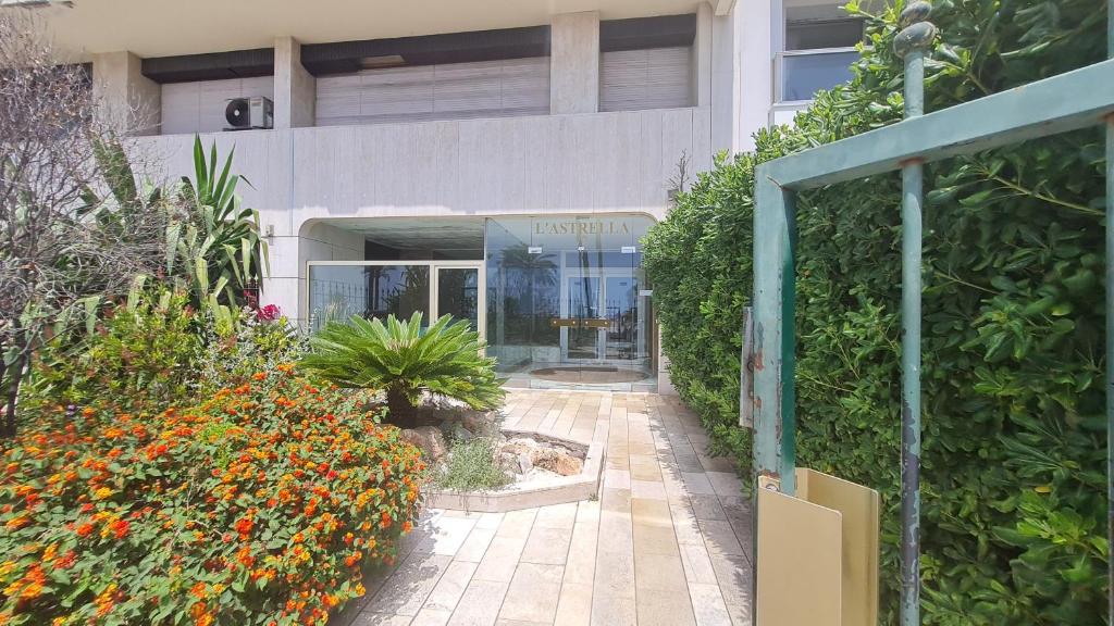 une entrée à un bâtiment avec des plantes et des fleurs dans l'établissement Petit studio promenade des Anglais, à Nice