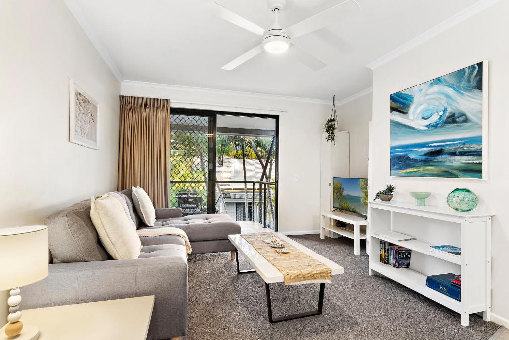 un soggiorno con un divano e un tavolo di Upstairs 1 Bedroom Unit in Noosaville Resort a Noosaville