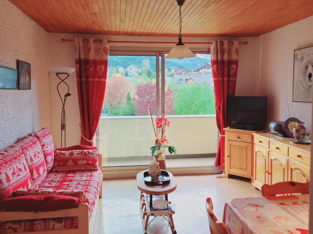un salon avec un canapé et une grande fenêtre dans l'établissement Appartement 2 pièces avec balcon plein sud, 6 couchages, parking privatif, proche centre Villard-de-Lans - FR-1-689-132, à Villard-de-Lans