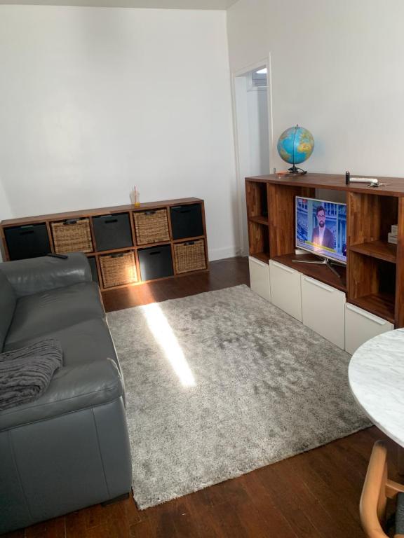 un salon avec un canapé et une télévision dans l'établissement Paris, à Aubervilliers