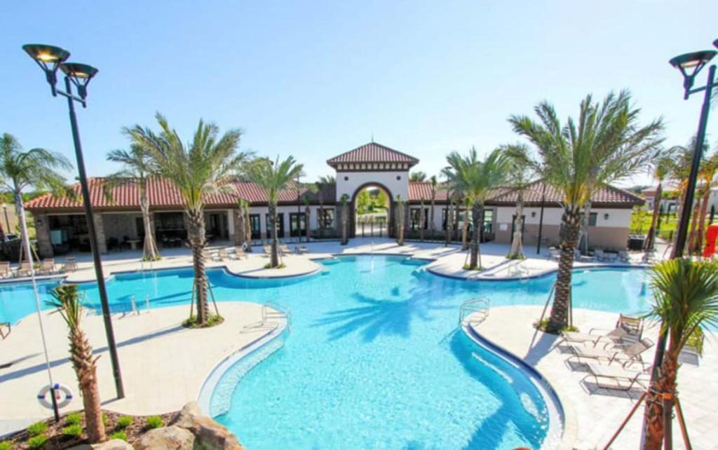 una piscina in un resort con palme e sedie di Orlando Relax a Davenport