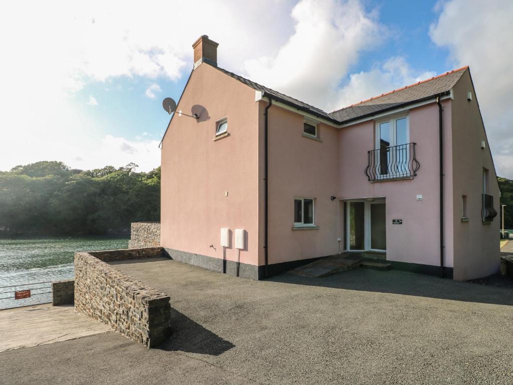 una casa en un muelle junto al agua en Curlew, en Milford Haven