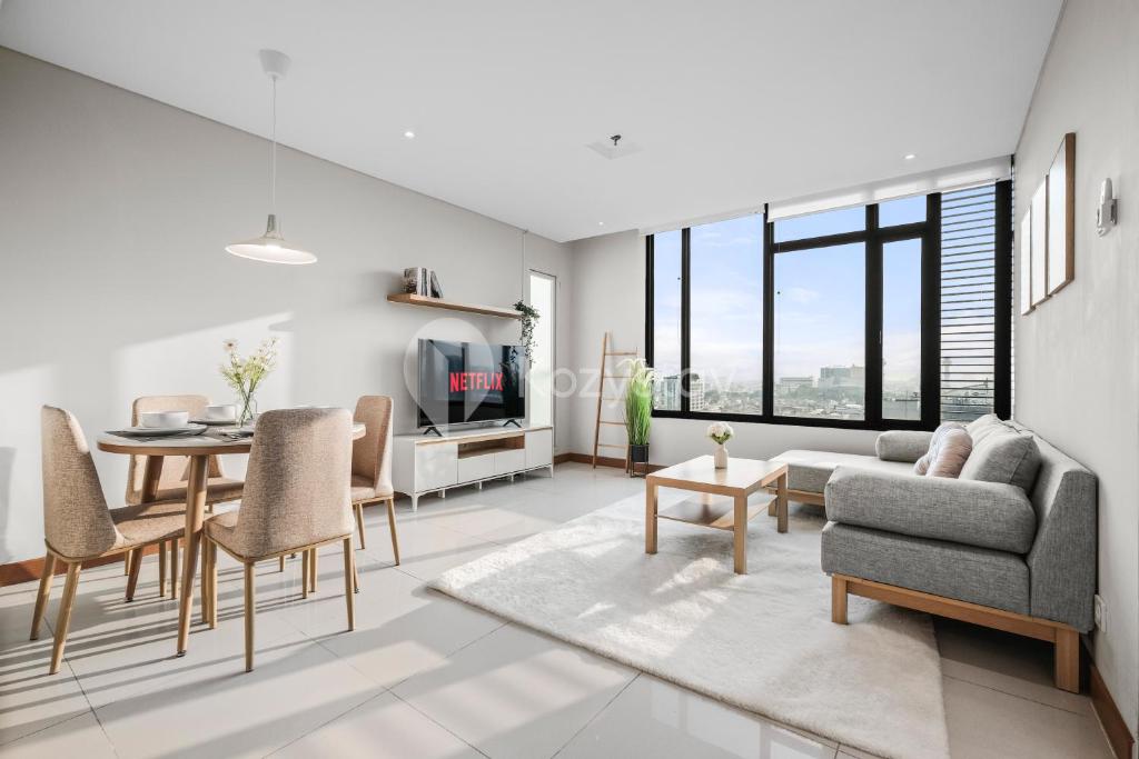 Savya ApartHotel by Kozystay - Bandung City في باندونغ: غرفة معيشة بها أريكة وطاولة