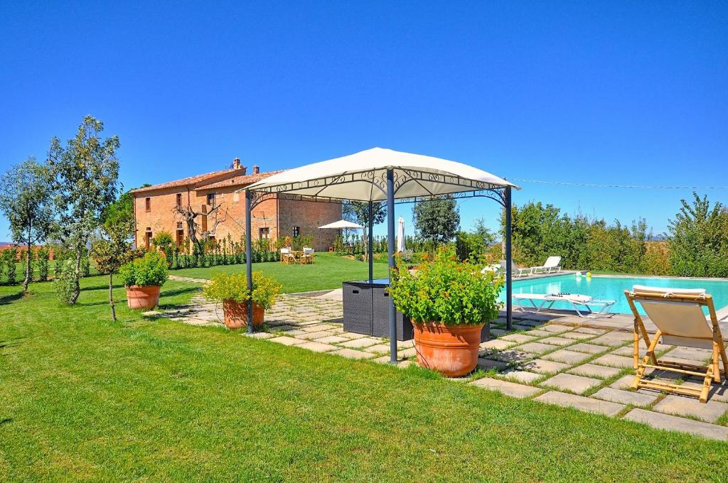a garden with a gazebo and a swimming pool at Romina by PosarelliVillas in Valiano