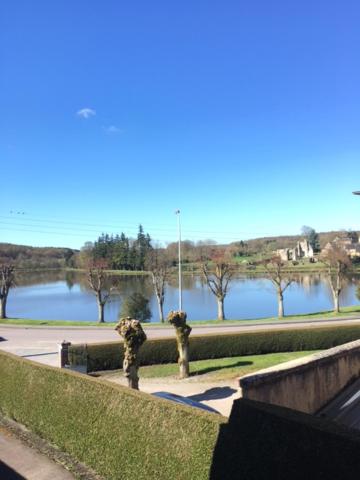 una vista di uno specchio d'acqua con alberi di Gîtes du duvet d'oie a Saint-Évroult-Notre-Dame-du-Bois