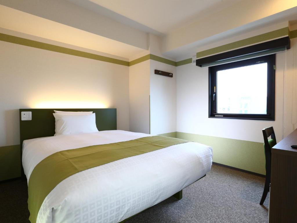 a bedroom with a large bed with a window at Hotel Wing International Select Ueno Okachimachi in Tokyo