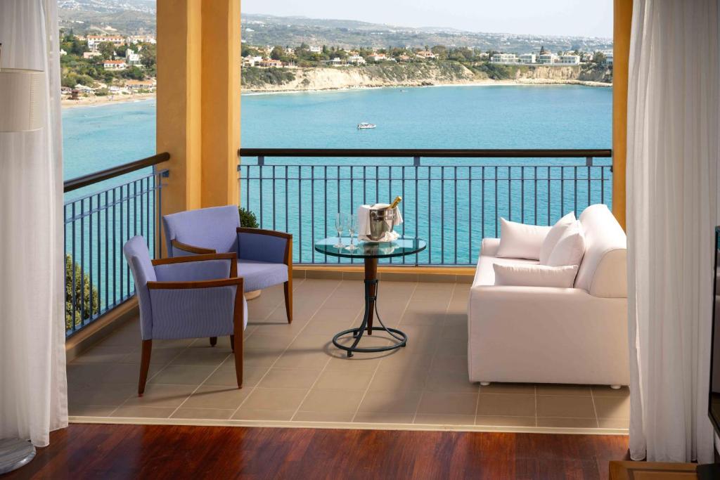 a balcony with a table and chairs and a view of the water at Thalassa Boutique Hotel & Spa in Coral Bay