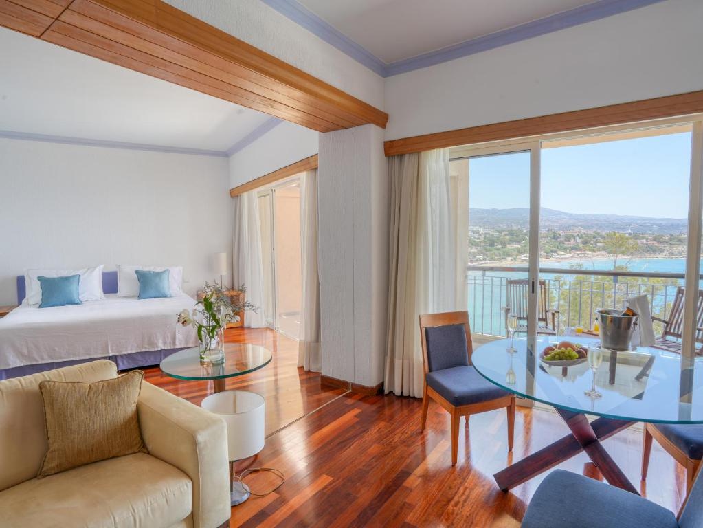 a living room with a bed and a glass table at Thalassa Boutique Hotel & Spa in Coral Bay
