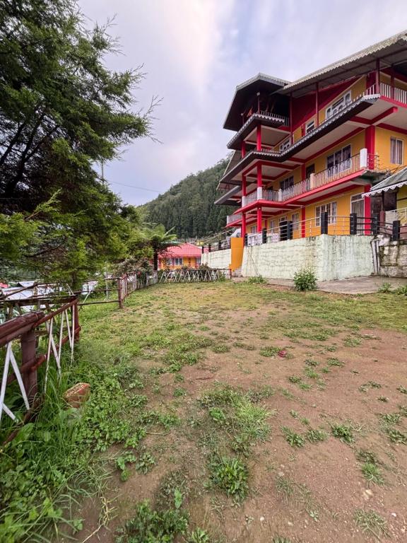 un bâtiment dans un champ devant un bâtiment dans l'établissement Heaven valley home stay, à Pedong