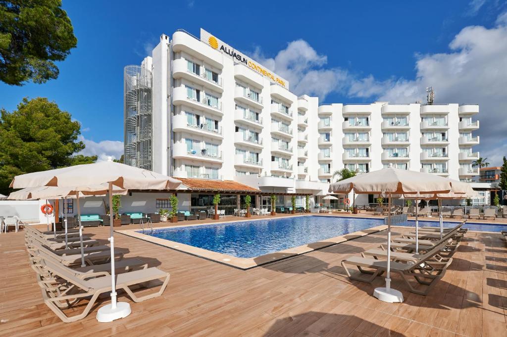 a hotel with a swimming pool with chairs and umbrellas at AluaSun Continental Park Hotel & Apartments in Playa de Muro
