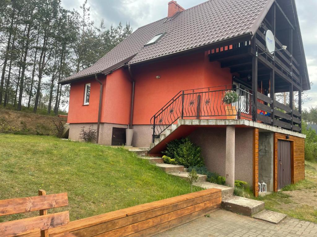 a house with a balcony on the side of it at Ptasi dół in Sulęczyno