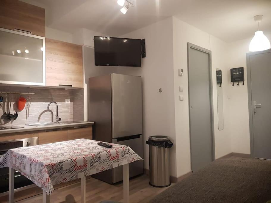 La cuisine est équipée d'une table, d'un évier et d'un réfrigérateur. dans l'établissement Le cocon, à Besançon