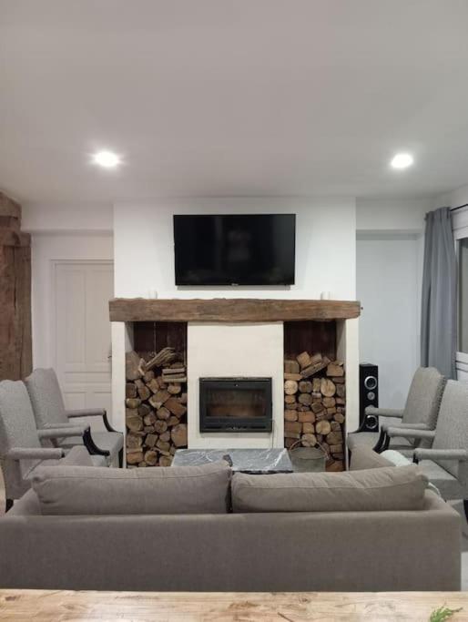 a living room with a fireplace with a flat screen tv at Casa Mayor in Huérmeces