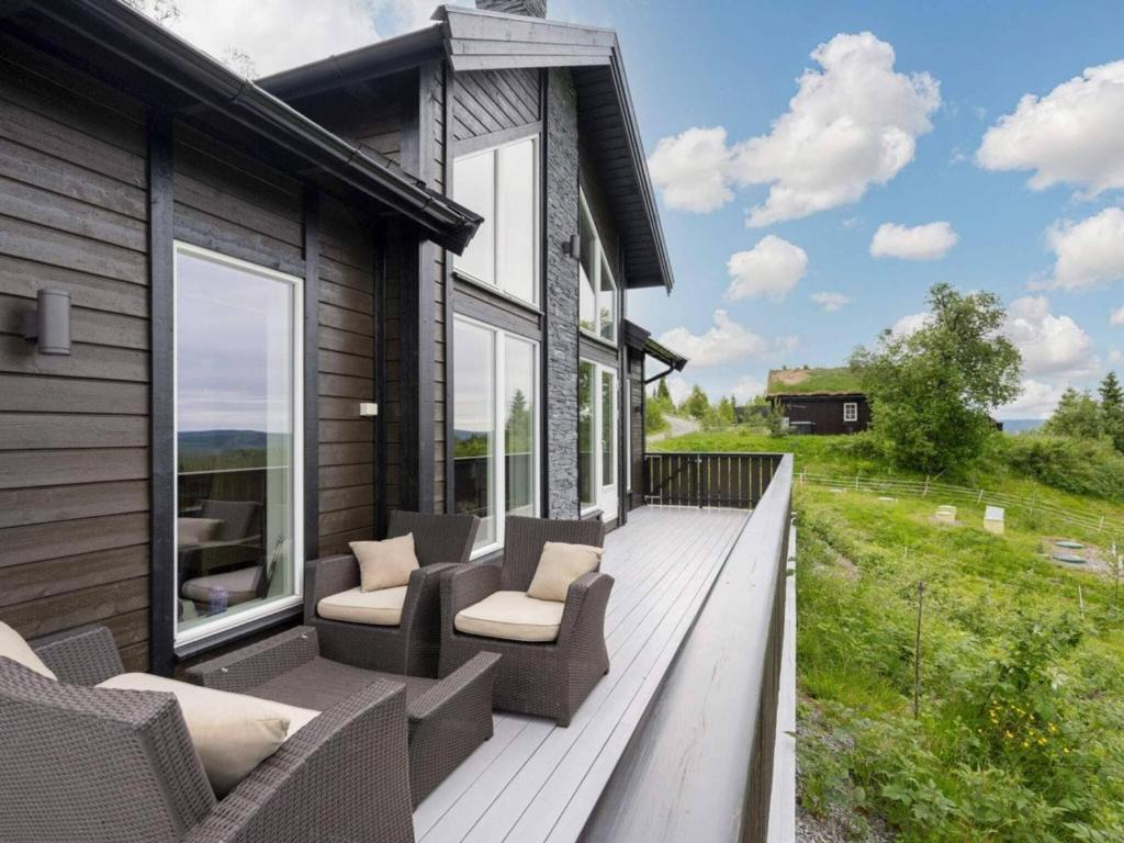 a wooden deck with chairs and a house at 4 star holiday home in Fall-By Traum in Raufoss