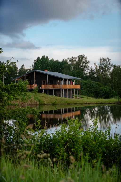 a building sitting on the side of a lake at Grava Cottage in Tukums