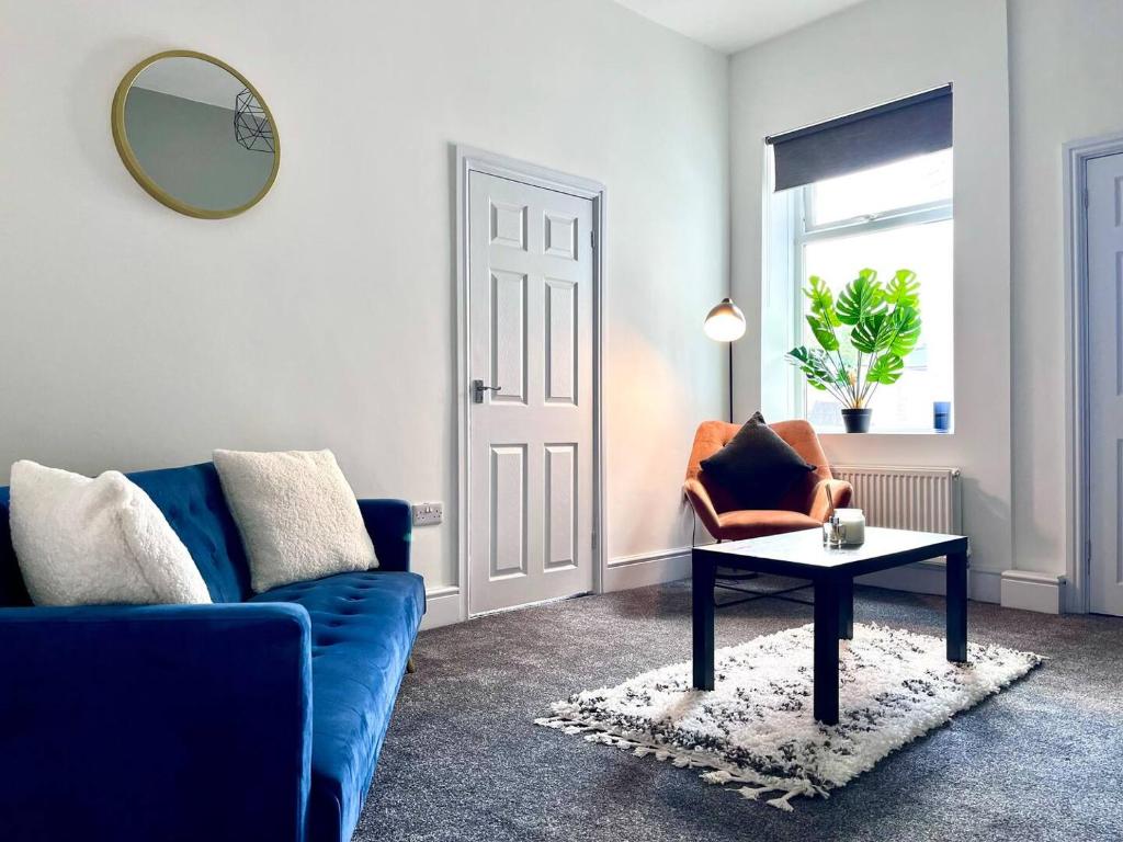 Outdoor Patio, Near Stadium Of Light, Refurbished في Monkwearmouth: غرفة معيشة مع أريكة زرقاء وطاولة