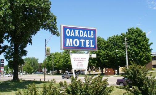 a sign for a motel in a parking lot at Oakdale Motel in Owatonna