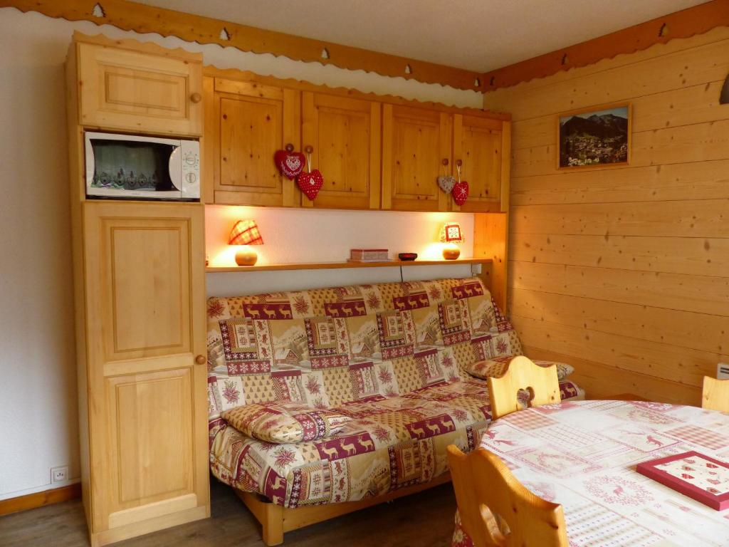- une chambre avec un lit et un four micro-ondes sur le mur dans l'établissement Christina CR12 FAMILY & QUIET 4 Pers, à Châtel
