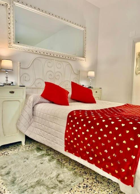 a bedroom with a bed with two red pillows at Casetta Ambretta in Monterosso al Mare