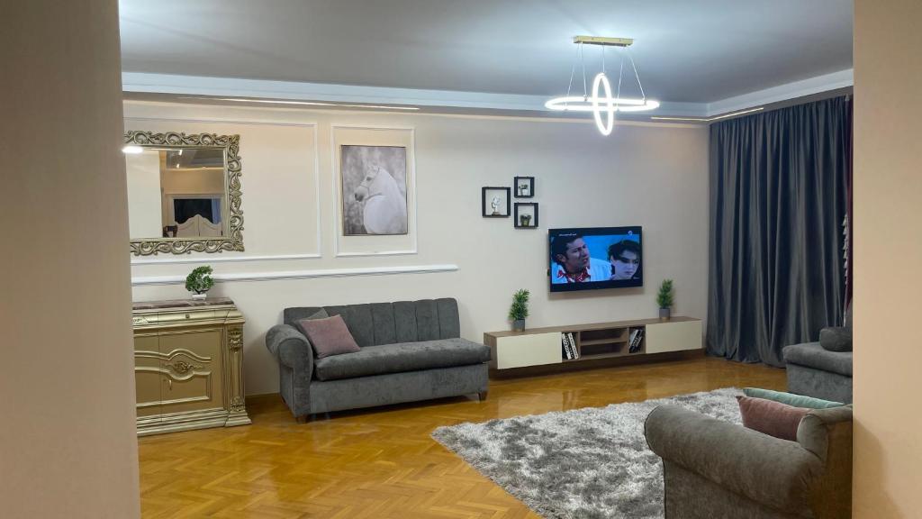 un salon avec deux chaises et une télévision dans l'établissement لؤلؤه ابراج الخليج, au Caire