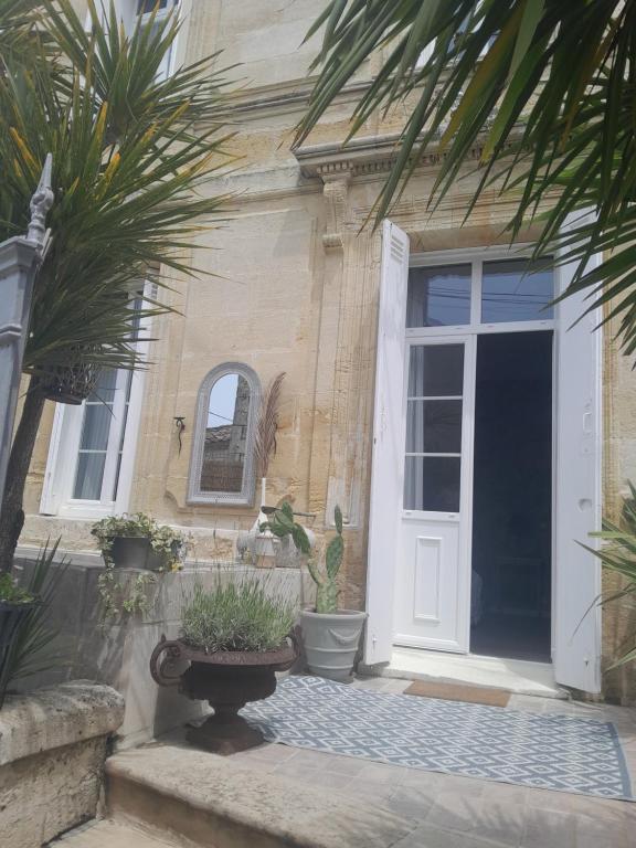 une maison avec une porte blanche et quelques plantes dans l'établissement le clos girona, à Civrac-en-Médoc